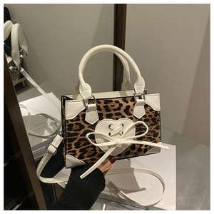 Detail of leopard print handbag with white heart bow and adjustable shoulder strap