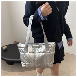 Silver quilted tote bag showing medium capacity and shoulder carrying style on a model
