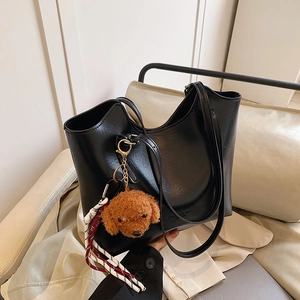 Large black leather tote bag for autumn with cute plush dog pendant and stylish ribbon