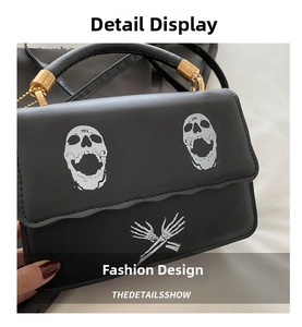 Detail of gothic skull print on black leather crossbody bag with gold handle