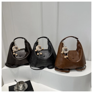 Maillard style leather tote bags in three colors with plush sheep pendants on a display