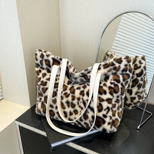 Faux fur leopard print tote bag with white leather straps in a stylish interior setting