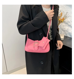 Pink shoulder bag with matching mini coin purse and golden buckle detail shown on model