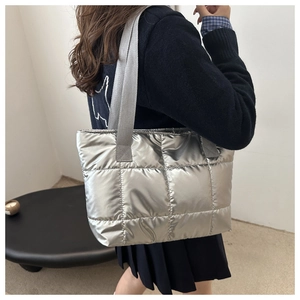 Detail view of silver quilted nylon tote bag with wide grey shoulder strap