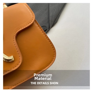 Makroaufnahme von orange-braunem mattem Leder und Präzisionsnähten an einer eckigen Tasche