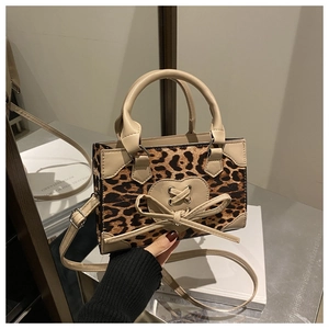 Detail of leopard print mini handbag with heart cross-lace and bow in retro chic style