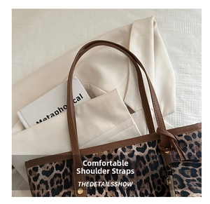 Detail of leopard print tote bag with brown leather shoulder strap and side zipper pocket