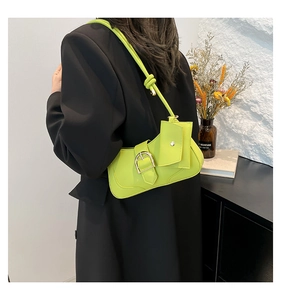 Detail of neon green crescent shoulder bag with small square pouch and metal buckle