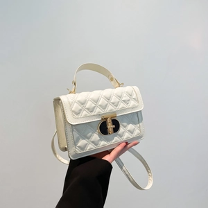 Chic white quilted crossbody bag with gold T-clasp hardware and handle strap