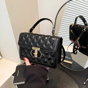 Black quilted leather square handbag with gold rotating clasp and adjustable shoulder strap