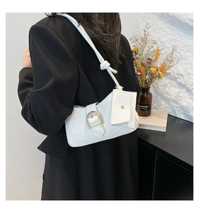 Close-up of white leather crescent shoulder bag with gold buckle and mini pouch detail