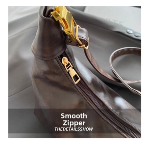Detail of smooth gold zipper and premium brown leather texture on stylish commuter bag