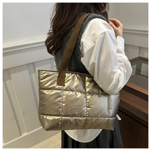 Macro view of metallic champagne gold quilted tote bag with square pattern stitching