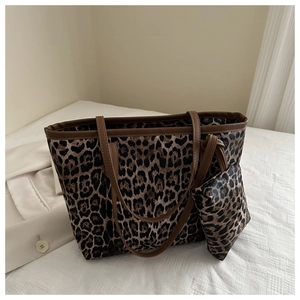 Detail van luipaardprint tote tas met bruine lederen randen en bijpassende pouch