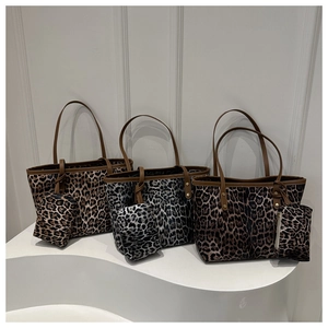 Three leopard print tote bags with matching small zipper pouches in classic colors