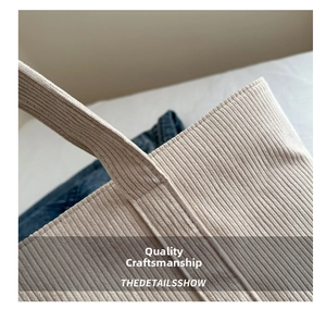 Close-up of beige corduroy tote bag showing high-density stitching and ribbed texture