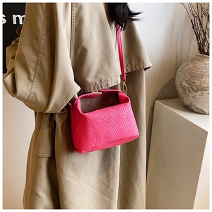 Detail der pinkfarbenen Lederhandtasche mit Gold-Schnalle an Model im Trenchcoat