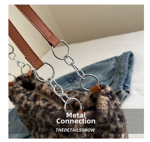 Close-up of leopard print plush tote bag with silver chain strap and leather handle