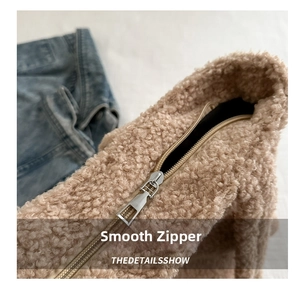 Detail of smooth metal zipper closure on a fuzzy light brown sherpa tote bag