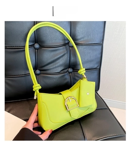 Detail of neon green crescent shoulder bag featuring large silver buckle and mini pouch