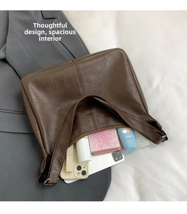Top view of brown pleated leather shoulder bag showing large interior capacity with zipper