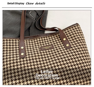 Detail of houndstooth tote bag featuring leather handles and gold rivet accents