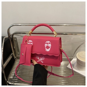 Pink matte leather crossbody bag with skull print and matching small pouch charm