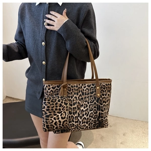 Detailweergave van de luipaard tote tas met bruine lederen handgrepen en kleine pouch