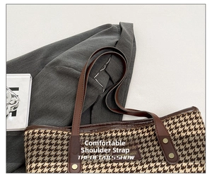 Detail of houndstooth tote bag with durable brown leather straps and metal rivets
