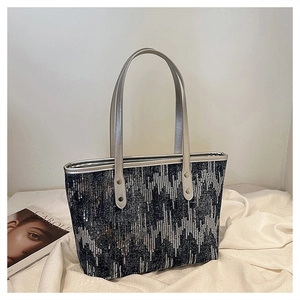 Detail of grey tote bag featuring silver sequin geometric patterns and slim metallic handles