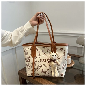 Close-up of bear tote bag with graffiti prints and a cute knit bear charm accessory