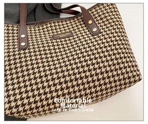 Close-up of houndstooth woven fabric and brown leather handle with gold metal rivets