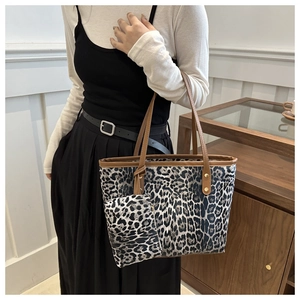 Detailopname van grote shopper met luipaardprint, bijpassend tasje en bruine lederen riemen