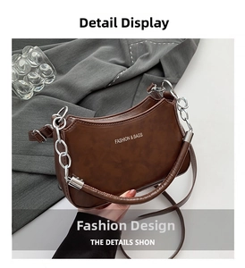 Detail showing matte brown leather texture and silver chain handle on crescent bag