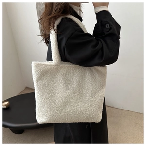 Detail of white faux shearling tote bag with soft texture and large capacity design