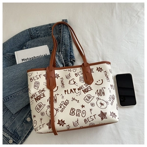 Detail of large tote bag with bear graffiti prints and brown leather trim accents
