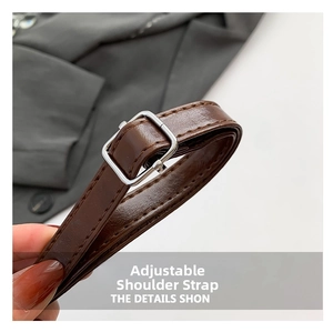 Close-up of adjustable brown leather shoulder strap with silver metal buckle detail