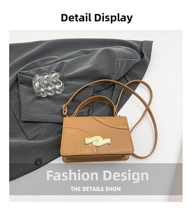 Detail of tan patchwork shoulder bag with crocodile texture and gold wavy buckle