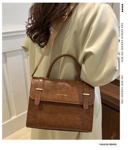 Vue arrière du mannequin portant un sac à bandoulière vintage marron avec boucle dorée