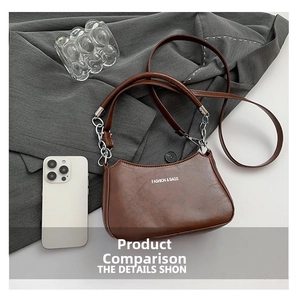 Detail of vintage brown PU leather shoulder bag with chain strap and printed lettering