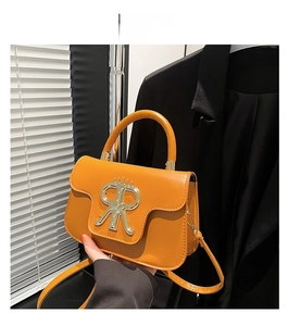 Detailansicht der braunen Ledertasche mit großer goldener Schnalle und Metallbeschlägen