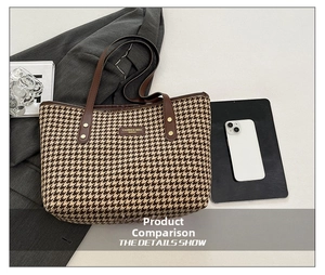 Detail of houndstooth tote bag showing leather handles, metal rivets and classic texture