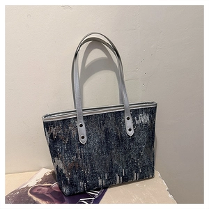 Close-up of sparkling navy sequins and silver leather handles on a stylish tote bag