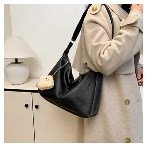 Detail of black large Hobo shoulder bag with faux leather texture and plush bear charm