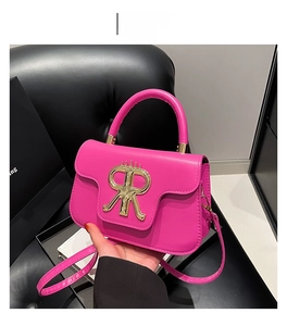 Nahaufnahme der fuchsiafarbenen Umhängetasche mit goldenem RR-Kronenlogo und PU-Leder