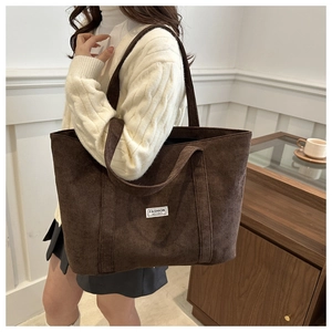 Detail of fashion instinct brand label on large brown corduroy tote bag for daily commute