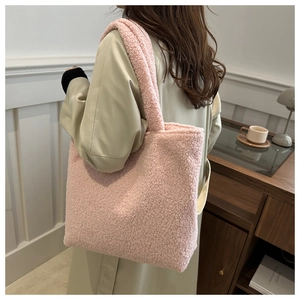 Detailed view of pink plush faux shearling tote bag styled with a light trench coat