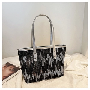 Detail of black tote bag featuring silver chevron sequins and metallic handles