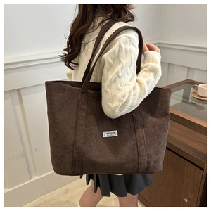 Brown corduroy tote bag detail showing thick ribbed texture and white square fabric label