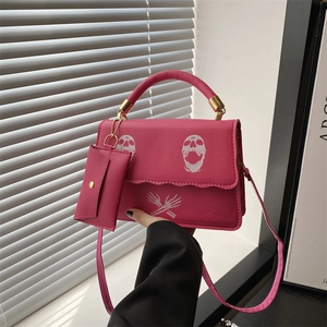 Hot pink shoulder bag with gothic skull print, featuring a mini pouch and gold chain strap
